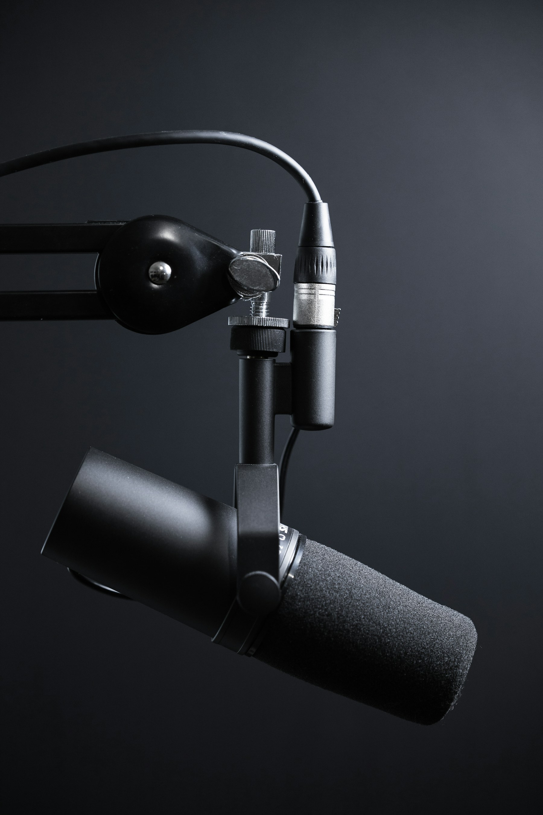 Professional broadcast microphone in podcast studio with amber lighting